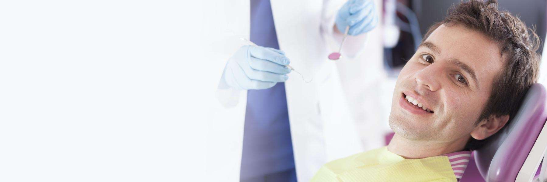 man smiling in dentist exam chair | dentist narre warren